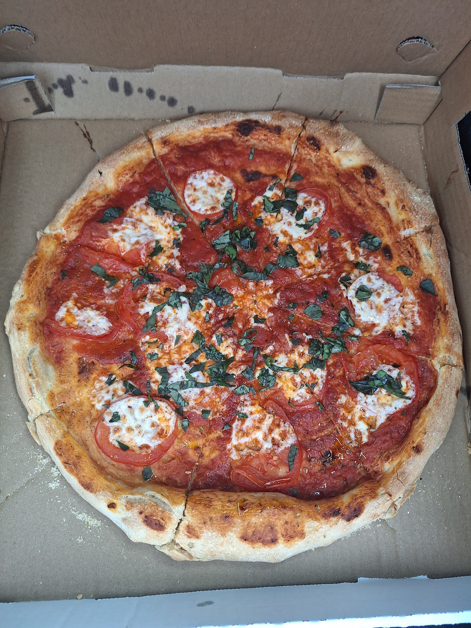 A whole pizza photographed at Mario's Home Style Pizza