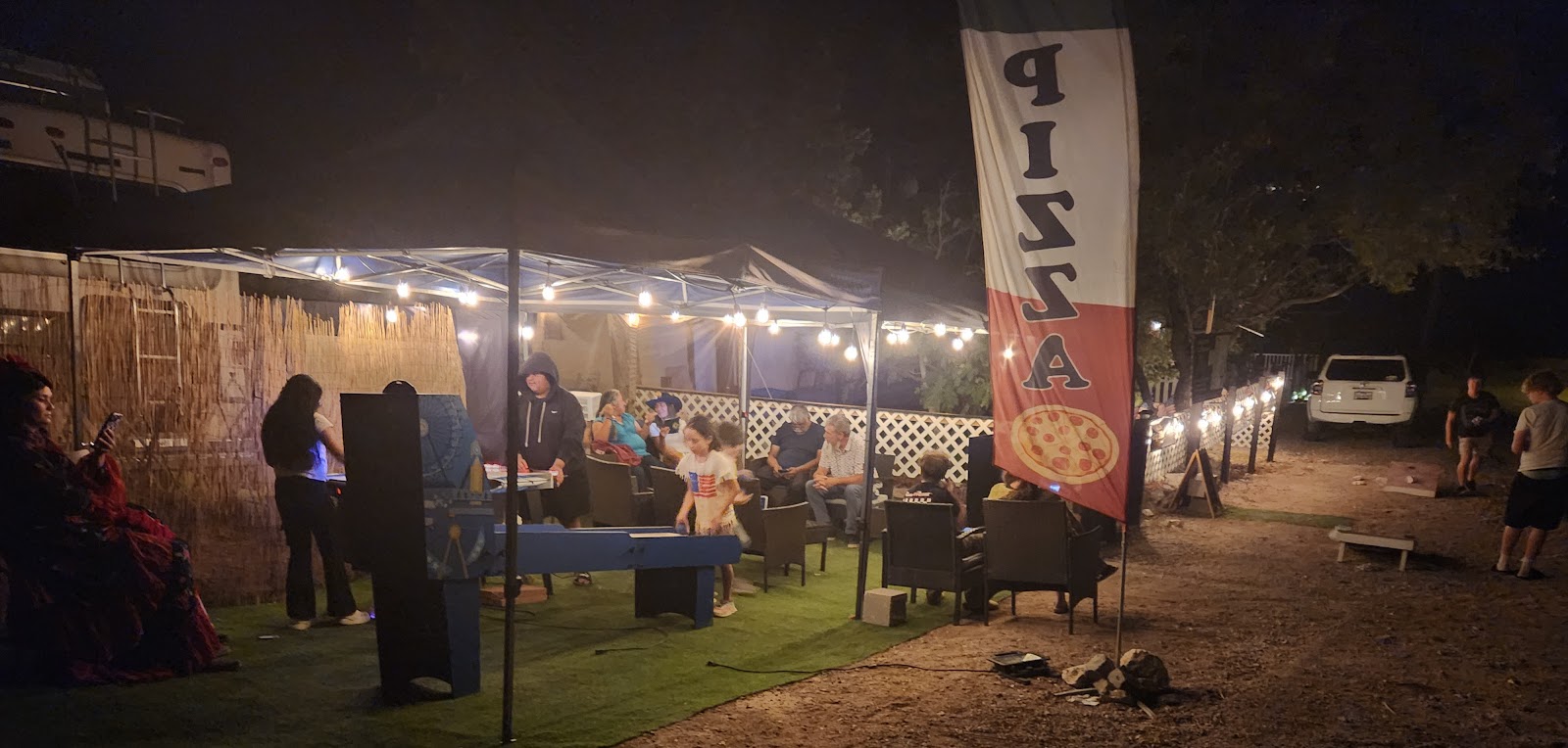 Outdoor dining environment at Mario's Home Style Pizza with a pizza banner